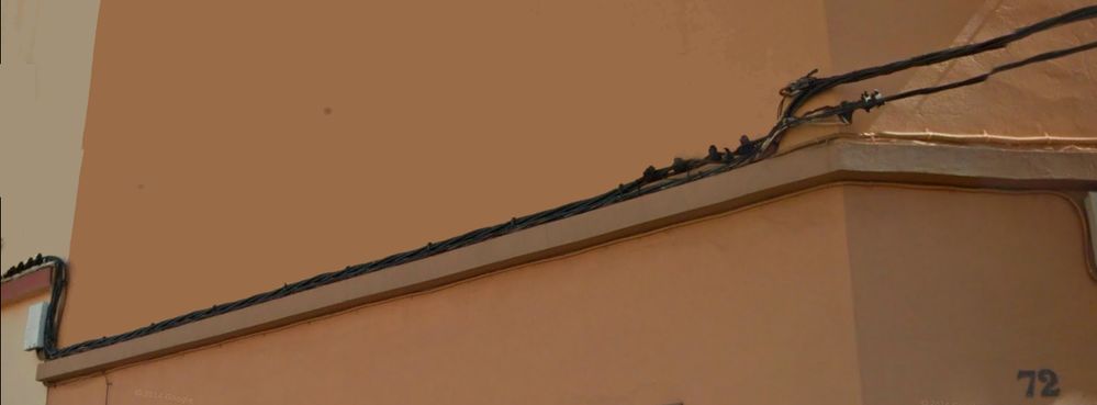 Cableado en la fachada del "trabajador de telefonica/movistar", que se niega a dejar pasar UN cable de fibra. Captura de Google Maps.