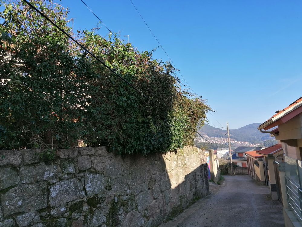 Al fondo Poste de Naturgy y mal atado de cables de Telefónica